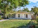 Inviting single-story home with a screened porch, landscaped front yard, and mature trees at 1179 Seminole St, Clermont, FL 34711