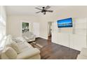 Bright living room featuring hardwood floors, a ceiling fan, and a built-in shelving unit at 1179 Seminole St, Clermont, FL 34711