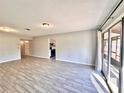 Open-concept living space with gray walls, wood-look tile floors and lots of natural light from sliding doors at 1232 Roma Ct, Orlando, FL 32825