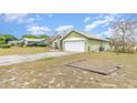 Green one-story home showing side and garage, with a well-maintained lawn at 14325 Golden View Dr, Grand Island, FL 32735