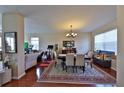 Bright open concept living and dining room with shiny wood floors, neutral walls and contemporary lighting fixture at 1750 Morning Sky Dr, Winter Garden, FL 34787