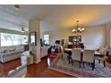 Bright open concept living and dining room with shiny wood floors, neutral walls and contemporary lighting fixture at 1750 Morning Sky Dr, Winter Garden, FL 34787