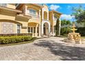 Beautiful Mediterranean-style home with a brick driveway, a fountain and manicured landscaping in the front yard at 225 Magnolia St, Windermere, FL 34786