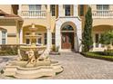 Elegant home featuring a stone fountain, manicured landscaping, and a double-door entryway with stone accents at 225 Magnolia St, Windermere, FL 34786