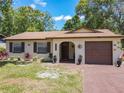 Charming, one-story home with a brick exterior, front lawn, and a driveway leading to an attached garage at 2617 S Marshall Ave, Sanford, FL 32773
