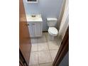 Compact bathroom featuring a white vanity, toilet, and a shower with a curtain, designed for functionality at 2618 Adela Ave, Orlando, FL 32826