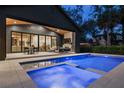 A well-lit backyard featuring a pool, spa, outdoor patio, fireplace, and exterior kitchen at 2814 Parkland Dr, Winter Park, FL 32789