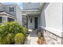 Inviting front entryway with stone pillars and neutral colors. Features well maintained landscaping at 2865 High Pointe St, Clermont, FL 34711