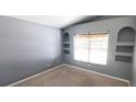 Cozy bedroom showcasing built-in display shelves, neutral walls, carpeted floor, and a window at 3131 Effingham Dr, Clermont, FL 34714
