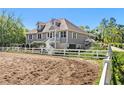 View of the home and paddock featuring a white fence and an exterior stairwell to the second story at 3149 Scrub Oak Trl, Oviedo, FL 32765