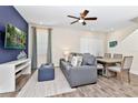 Cozy living room with blue accent wall, modern furniture, ceiling fan, and adjacent dining area at 3192 Caribbean Soul Dr, Kissimmee, FL 34747
