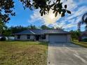 Charming single-story brick home featuring a two-car garage and well-maintained lawn at 324 Bonita Rd, Debary, FL 32713