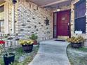 Inviting front porch with brick facade and a red front door with decorative potted plants at 324 Bonita Rd, Debary, FL 32713