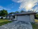 Close up view of a single story home's two-car garage and driveway on a sunny day at 324 Bonita Rd, Debary, FL 32713