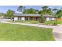 Well maintained ranch home featuring lush landscaping, a circle drive, and updated exterior at 400 Royal Palm Ct, Longwood, FL 32779
