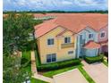 An aerial view of the townhome showcasing the red tile roof, landscaping, and overall community at 4720 Hemingway House St, Kissimmee, FL 34746