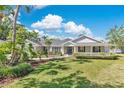 Charming single-story home featuring a well-manicured lawn, mature landscaping and a covered front porch at 673 Balmoral Rd, Winter Park, FL 32789