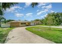 Single story home boasts a stone facade, two-car garage, and extra-long driveway with ample space at 690 S Lakemont Ave, Winter Park, FL 32792