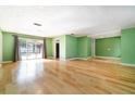 Spacious living room showcasing shiny hardwood floors, sliding glass doors, and green colored walls at 690 S Lakemont Ave, Winter Park, FL 32792