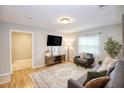 Comfortable living area with sleek media console, plush sofa, and natural lighting through sheer window at 7714 Lady Frances Way, Orlando, FL 32807