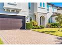 Close up of exterior elevation, showing stone archway, large garage door, and landscaped front yard at 8384 Ludington Cir, Orlando, FL 32836