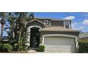 Charming two-story home featuring an attached two car garage and well maintained landscaping with palm trees at 8500 Palm Harbour Dr, Kissimmee, FL 34747