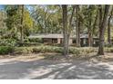 Secluded single-story home surrounded by mature trees and manicured hedges at 9676 Wild Oak Dr, Windermere, FL 34786