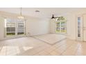 Bright living room featuring tile flooring, ceiling fan, and large windows that offer ample natural light at 1002 Kelsey Ave, Oviedo, FL 32765
