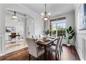 Formal dining room featuring decorative wall trim, hardwood floors, and an elegant chandelier at 10176 Hart Branch Cir, Orlando, FL 32832