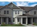 Townhome with light-colored siding, dark-gray trim, and a covered entrance framed by white pillars at 13532 Autumn Harvest Ave, Winter Garden, FL 34787