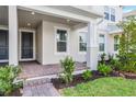 Inviting front porch with brick pavers, manicured landscaping, and neutral-tone exterior at 13532 Autumn Harvest Ave, Winter Garden, FL 34787
