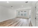 Bright living room featuring hardwood floors, recessed lighting, and three large windows at 13532 Autumn Harvest Ave, Winter Garden, FL 34787