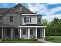 Exterior view of a two-story house with grey siding, black shutters and white pillars on the front porch at 13817 Luna Harvest Ave, Winter Garden, FL 34787