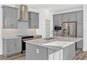 Modern kitchen with gray cabinets, stainless steel appliances, granite countertops, and a stylish backsplash at 13817 Luna Harvest Ave, Winter Garden, FL 34787