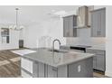Well-lit kitchen featuring a spacious island, stainless steel appliances, modern lighting, and an open layout at 13817 Luna Harvest Ave, Winter Garden, FL 34787