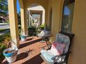 Charming covered patio with brick flooring, comfortable seating, potted plants, and elegant arched columns at 15149 Canoe Pl, Winter Garden, FL 34787