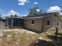 View of the house exterior showing the backyard with a screened porch at 2108 Wolf Rd, Orlando, FL 32808