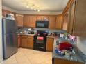 A full kitchen with stainless steel appliances and tile floors at 2108 Wolf Rd, Orlando, FL 32808