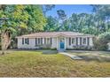 Lovely single-story home with manicured lawn, tidy shrubbery, and an inviting blue front door at 225 N Phippen Ave, Deland, FL 32724