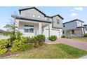 Well-maintained two-story home with an attached garage, brick driveway, and professionally landscaped yard at 2290 Sw Raven Ridge Rd, Clermont, FL 34715