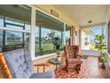 Inviting screened porch with comfortable seating, decorative tile flooring, and views of the neighborhood at 2811 S Peninsula Dr, Daytona Beach, FL 32118