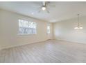 Open living area featuring wood-look tile flooring, large window, and a glass paneled front door at 2962 Firebush Way, Clermont, FL 34711