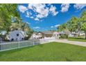 Expansive backyard featuring a white picket fence, lush green grass, mature trees, and a detached shed at 3000 Amherst Ave, Orlando, FL 32804