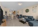 Open-concept living area with tile floors, comfortable seating, and adjacent breakfast bar at 3840 Cedarwaxwing Ave, Orlando, FL 32822