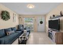 Cozy living room with tile flooring, comfortable seating, and natural light from a window at 3840 Cedarwaxwing Ave, Orlando, FL 32822