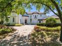 Elegant two-story home featuring a brick driveway, manicured landscaping, and a stately entrance at 5067 Latrobe Dr, Windermere, FL 34786