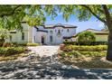Elegant two-story home featuring a brick driveway, manicured landscaping, and a stately entrance at 5067 Latrobe Dr, Windermere, FL 34786