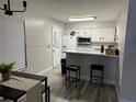 Well-lit kitchen features white cabinets, modern appliances, and a breakfast bar with seating at 5427 Hansel Ave # 9, Orlando, FL 32809