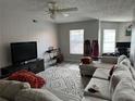 Spacious living room with comfortable sectional sofa, television, ceiling fan, and abundant natural light at 5427 Hansel Ave # 9, Orlando, FL 32809
