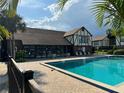 Community pool with lounge chairs and shaded seating areas surrounded by lush landscaping at 5427 Hansel Ave # 9, Orlando, FL 32809